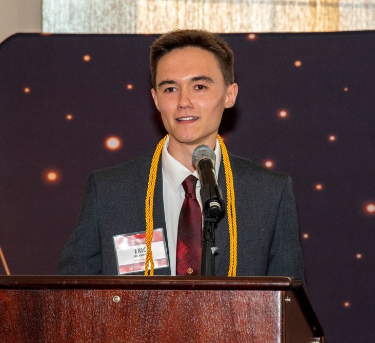 student speaking at lectern at event