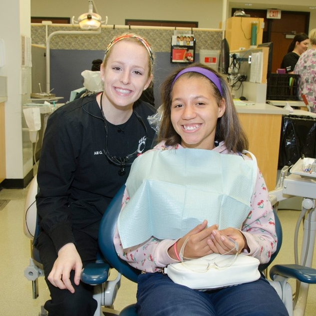 student dental hygienist and child patient smiling