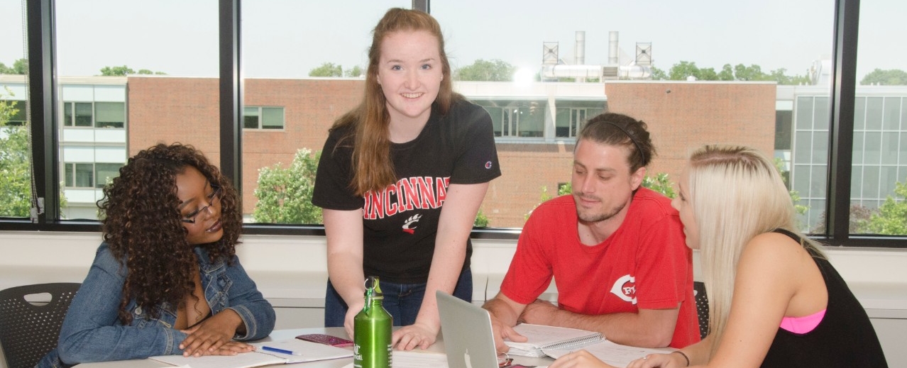Students collaborating around desk in classroom
