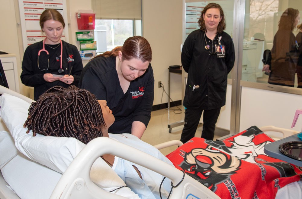 Nursing students working in the simulation lab with a professor