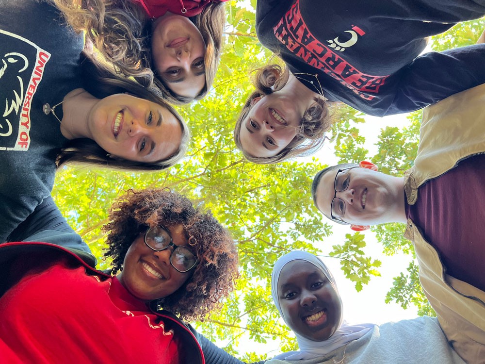 six students looking down into camera and smiling