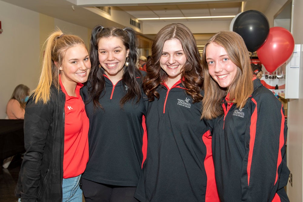 Four student ambassadors smiling in school hallway