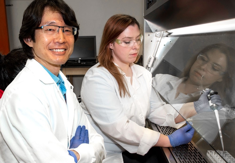 Student and professor working with lab equipment