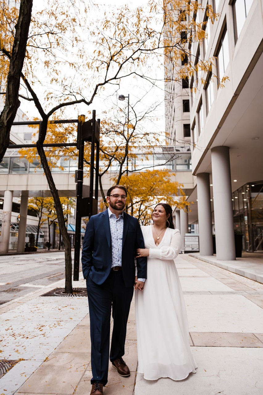 couple smiling on a city street in the fall