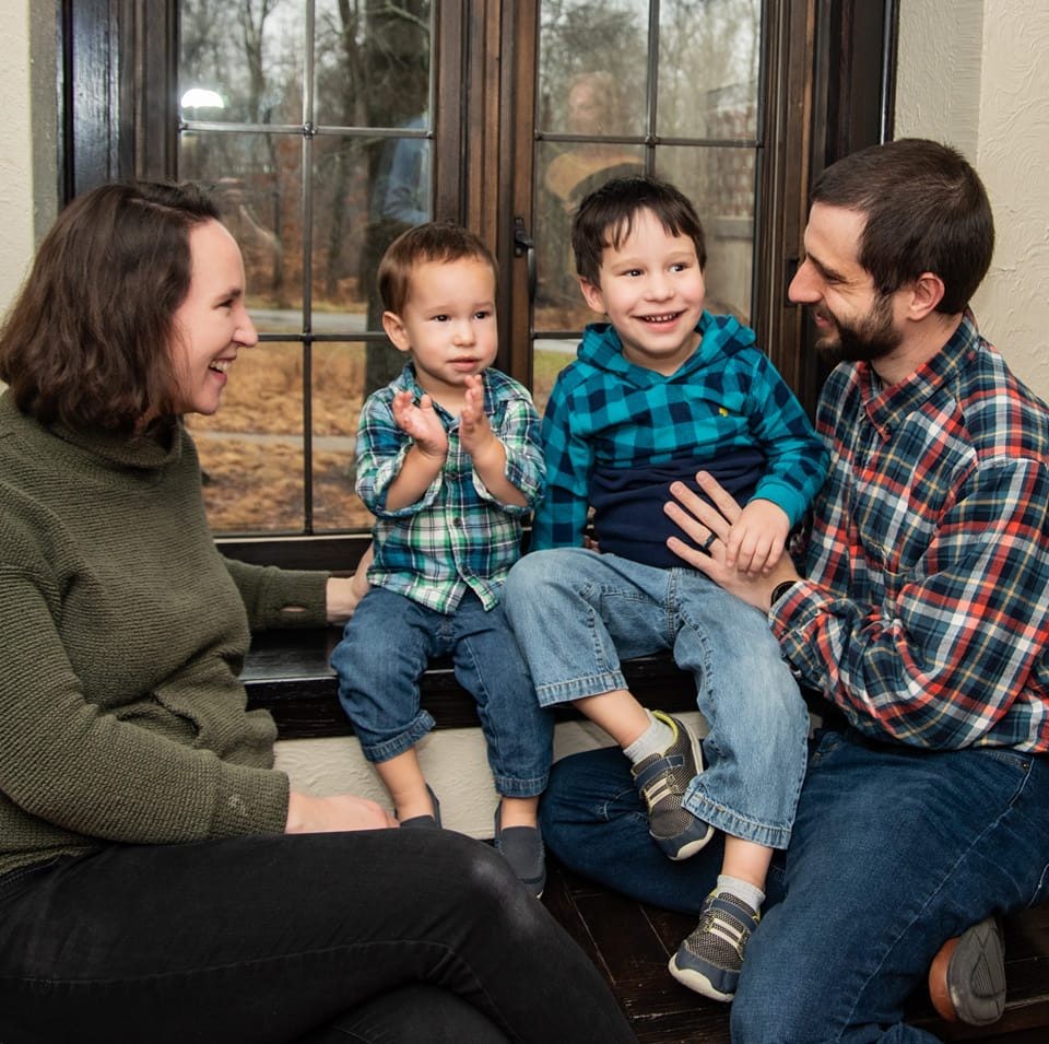 Family of four sitting by window